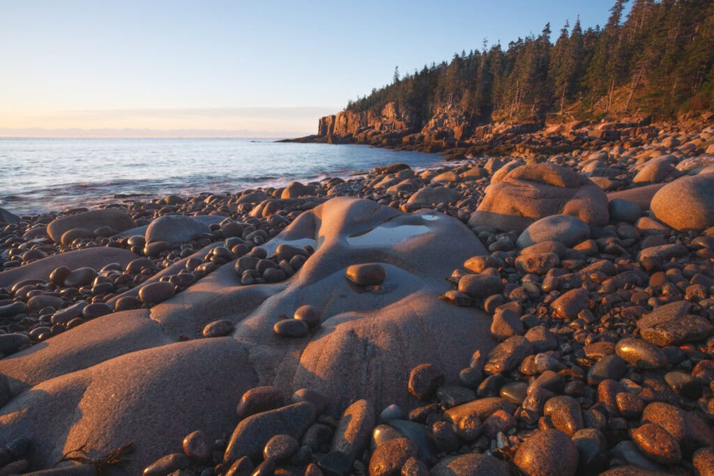 Pooled Light color photograph of golden sunrise light on rounded granite boulders and cobble beach, Otter Cliffs, Acadia National Park, Maine, fine art landscape photography by Brad Emerson