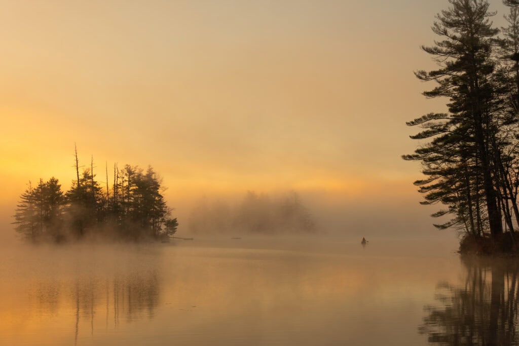 Season's Last Paddle color photograph of lone kayaker in morning fog and golden sunrise light on still lake, Thompson Lake, Otisfield, Maine, LFI Mastershot fine art photography by Brad Emerson